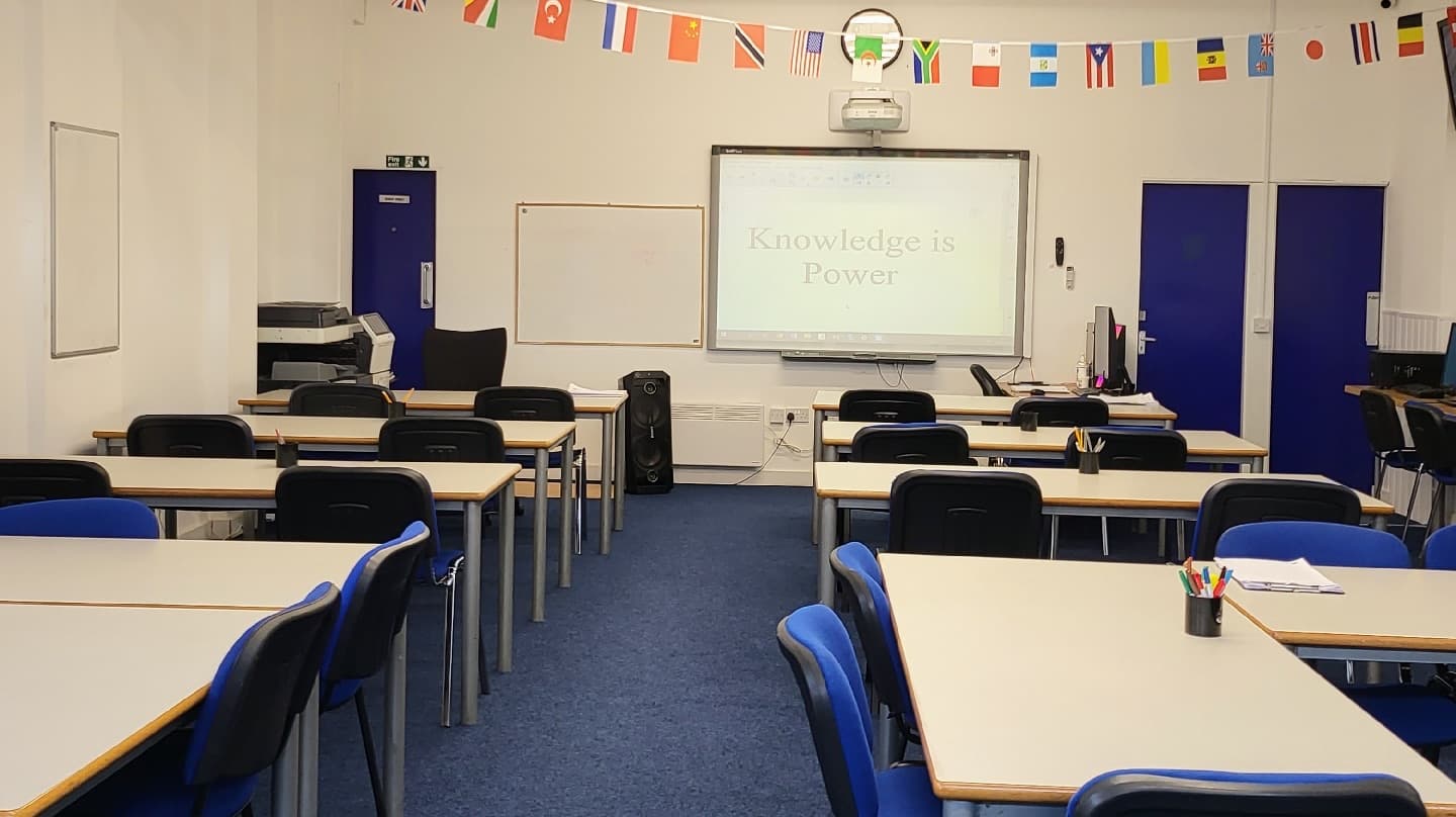 Classroom at the Longsight centre with desks and a projector screen